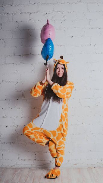 pajamas in the form of a giraffe. emotional portrait of a girl on a gray background. crazy and funny man in a suit. clean skin and long hair. animator for children's parties - Фото, зображення