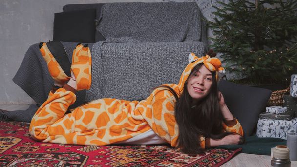 pajamas in the form of a giraffe. emotional portrait of a girl on a gray background. crazy and funny man in a suit. clean skin and long hair. animator for children's parties - Photo, image