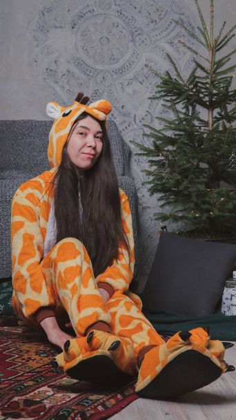pajamas in the form of a giraffe. emotional portrait of a girl on a gray background. crazy and funny man in a suit. clean skin and long hair. animator for children's parties - Foto, Imagem