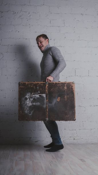 スーツケース、休暇パッケージを持つ男。男は、巨大なスーツケースを持って旅行に行きます。コンセプト: 休暇と休暇. - 写真・画像