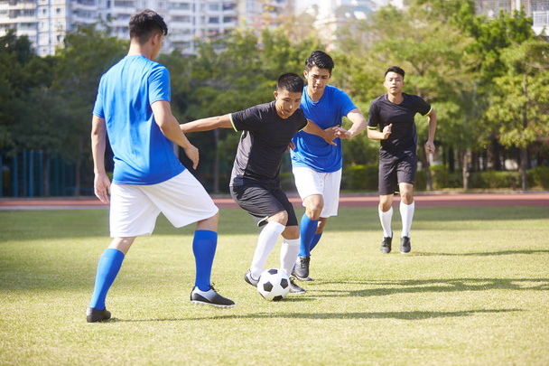 Grupa młodych Azji piłka nożna piłkarz na odkrytym korcie. - Zdjęcie, obraz