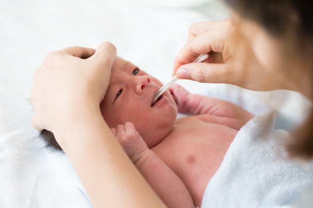 Asiatico neonato pulizia lingua, guancia rigonfiamento e bocca dopo il bagno
 - Foto, immagini