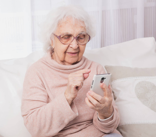 Great-grandmother talking by smartphone - 写真・画像