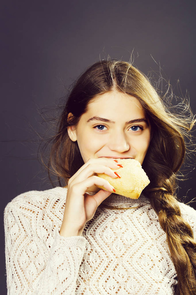 sexy young girl eating bread roll - Foto, imagen