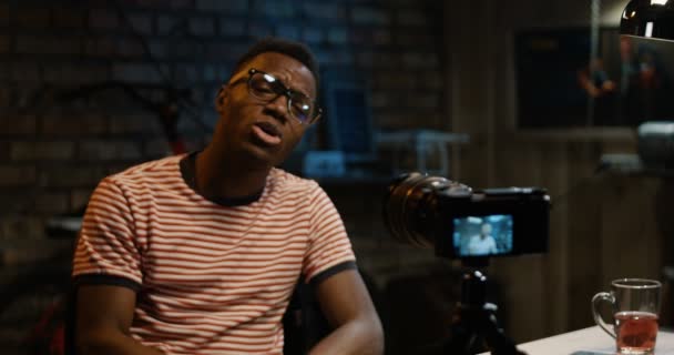 Νεαρός άνδρας που μιλούν στην κάμερα σε ένα γκαράζ - Πλάνα, βίντεο