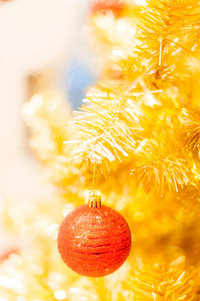 Glittering Bauble with Glowing Sparkling Gold defocused Light (bokeh) Illumination background with decorated Christmas Tree. Special Holidays, Festival design decoration, New Year Celebration, Party. - Foto, Bild