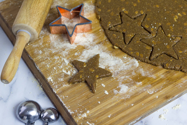 Hacer galletas de avena estrella en la cocina antes de Navidad para Papá Noel
 - Foto, imagen