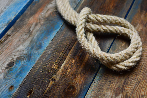 Nautical rope knot on a weathered wooden desk - Photo, Image