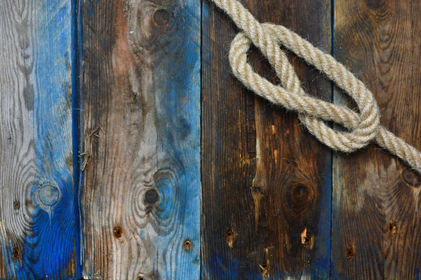 Ναυτικά σχοινί κόμπο σε ένα ξεπερασμένο ξύλινο κατάστρωμα - Φωτογραφία, εικόνα