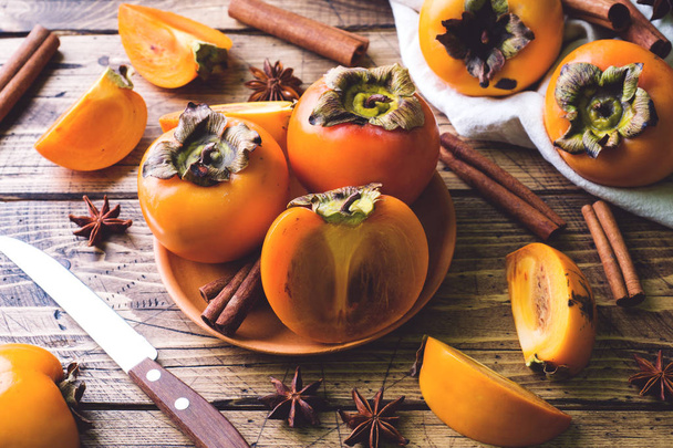 Fresh ripe persimmon on a wooden table. - Foto, imagen