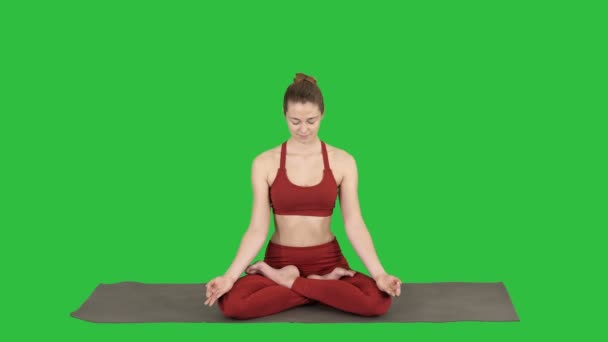 Smiling woman yoga meditating sitting lotus, hands coupled on a Green Screen, Chroma Key. - Footage, Video