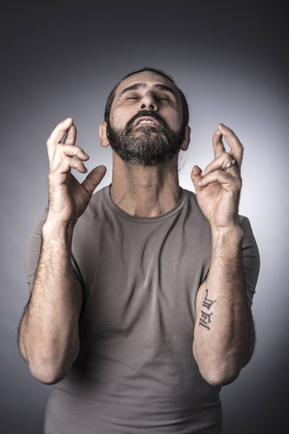 portrait of caucasian man crossing finger with closed eyes - Foto, afbeelding