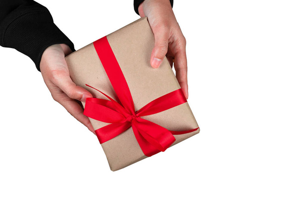Bonus Mensch Hand geben ein Geschenk braun Geschenkbox Fliege rotes Band isoliert auf weißem Hintergrund mit Clipping Pfad Draufsicht frohe Weihnachten und ein glückliches neues Jahr Konzept - Foto, Bild