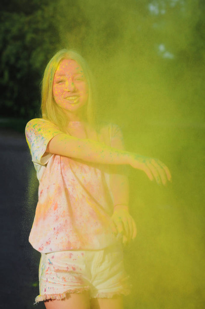 Piacevole ragazza bionda che gioca con polvere secca gialla esplosiva al Festival di Holi
  - Foto, immagini