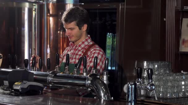 Męski barman leje i serwujemy pyszne craft piwo w pubie, w jego - Materiał filmowy, wideo