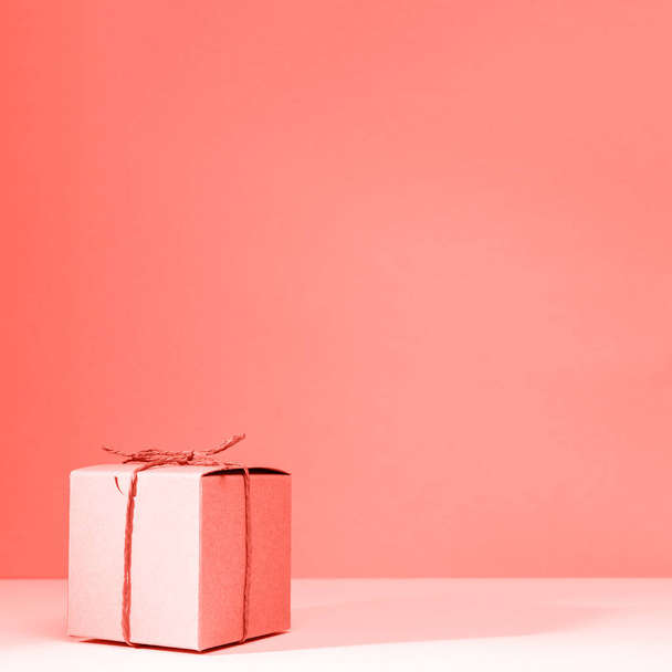 Створення подарункової коробки з картону на твердому рожевому тлі. Концепція свята та подарунка. Квадрат. Жива коралова тема - колір року 2019
 - Фото, зображення