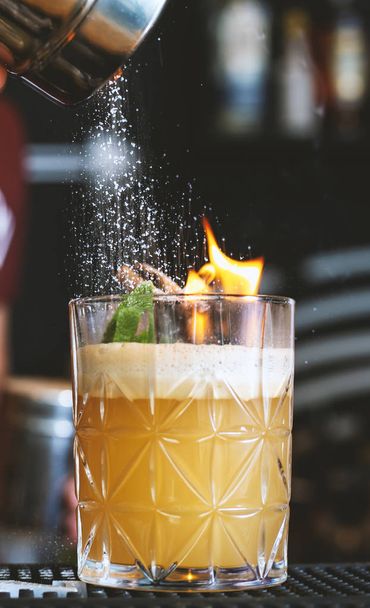 Бармен разжигает пламя за коктейлем
   - Фото, изображение
