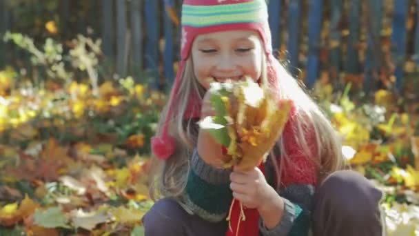 Όμορφο, μικρό κορίτσι παίζει με κίτρινο το φθινόπωρο, φύλλα στο πάρκο. Η έννοια του φθινοπώρου - Πλάνα, βίντεο