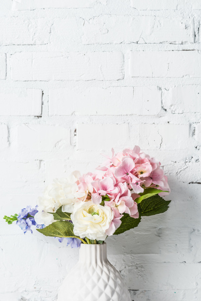 bouquet  in ceramic vase near white brick wall - Photo, Image