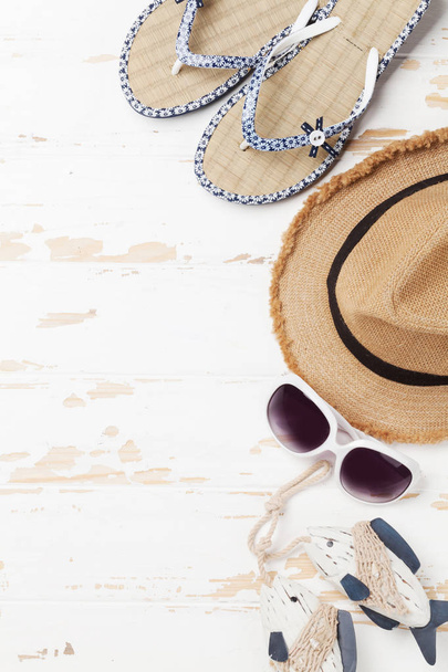 Travel vacation background concept with sun hat, sunglasses, flip flops and fish decor on wooden backdrop. Top view with copy space. Flat lay - Photo, Image