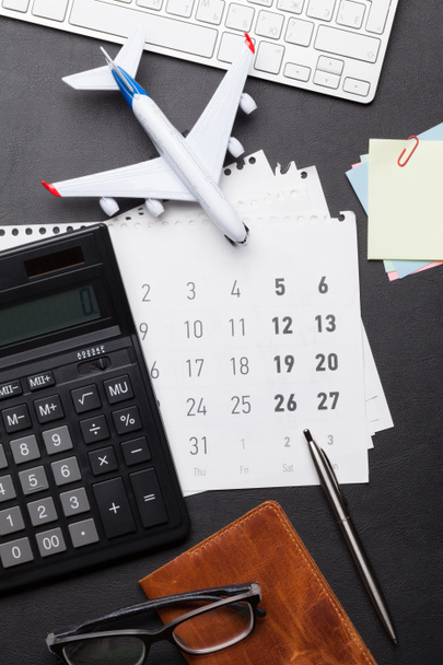 Concept de voyage d'affaires. Accessoires sur table de bureau. Clavier PC, passeport, bloc-notes, calendrier et jouet d'avion. Vue du dessus
 - Photo, image
