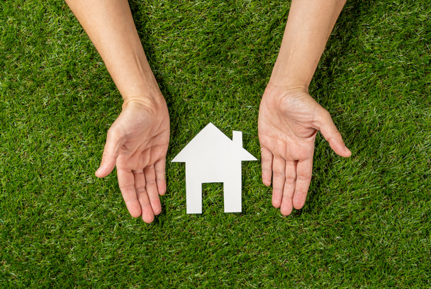 Концептуальная картина женских рук, защищающих белый дом на зеленом поле вид сверху и копировать пространство в инвестиции в недвижимость Сохранение и покупка ипотечного страхования и банковской концепции
. - Фото, изображение
