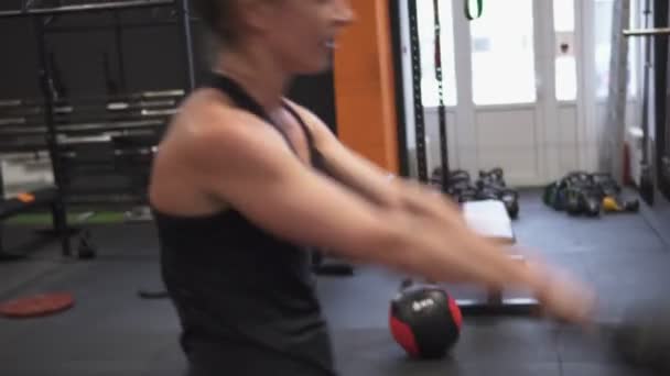 Fitness woman doing kettlebell swing cross training in gym - Materiaali, video