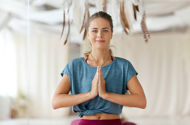 woman with namaste gesture at yoga studio - Фото, изображение