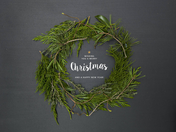 christmas wreath of green fir branches on black background  - Foto, afbeelding