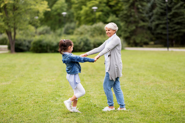 grandmother and granddaughter playing at park - 写真・画像