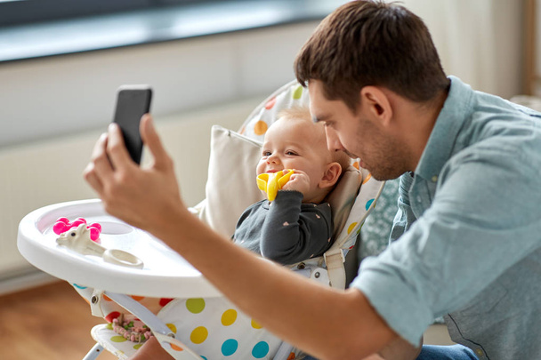 father with baby daughter taking selfie at home - Fotoğraf, Görsel