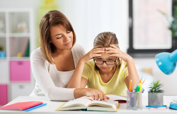 mother helping daughter with difficult homework - Photo, image