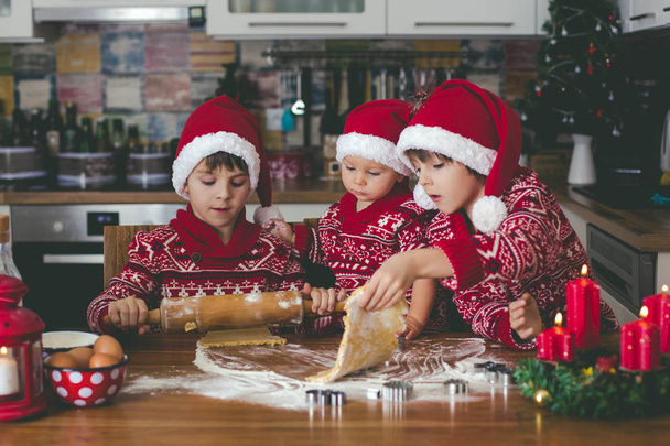 Enfant tout-petit doux et son frère aîné, garçons, aider maman à préparer des biscuits de Noël à la maison dans la cuisine - Photo, image