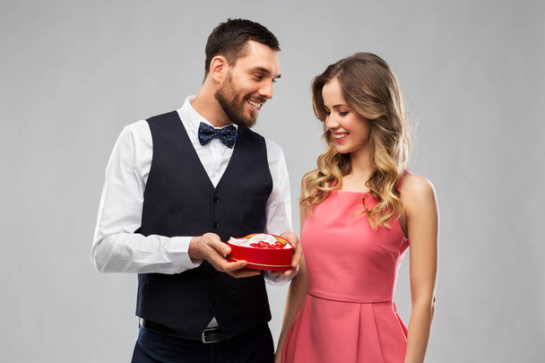 happy couple with chocolate box in shape of heart - Fotoğraf, Görsel