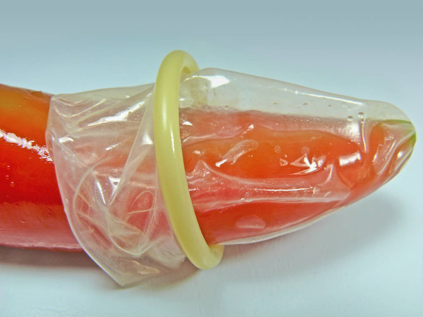 condoom op rode Spaanse peper - Foto, afbeelding