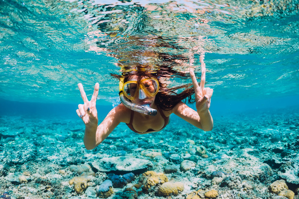 Onnellinen nuori nainen uimassa veden alla trooppisessa meressä
 - Valokuva, kuva