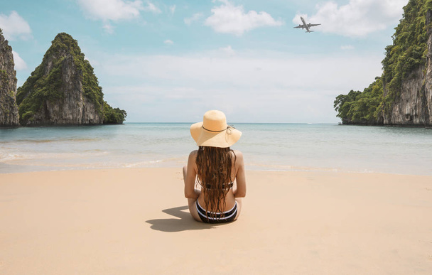 vue arrière de la femme en chapeau assis sur la plage tropicale
 - Photo, image