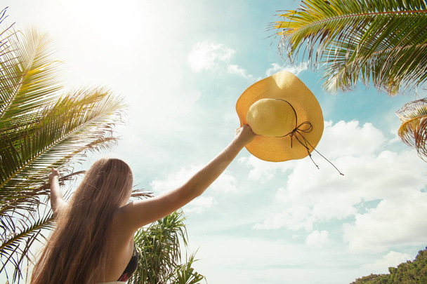 vista trasera del sombrero de mujer con plantas tropicales
 - Foto, Imagen