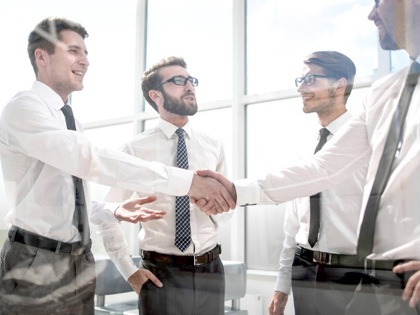 successful employees shaking hands at the workplace in the offic - Φωτογραφία, εικόνα
