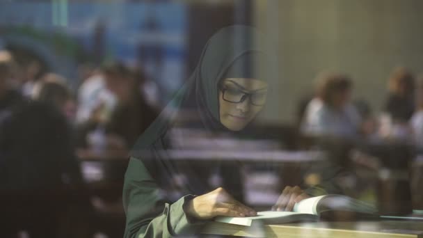 Jong Arabisch dame leesboek in café, studenten voorbereiden op examens, literatuur - Video