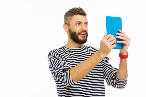 Joyful emotional man taking photo on his tablet - Zdjęcie, obraz