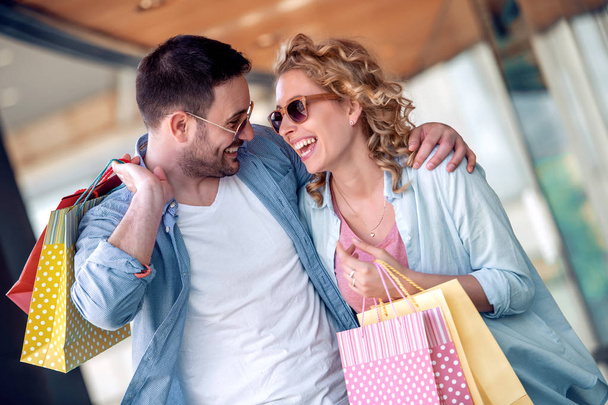 Şehirde alışveriş torbaları olan bir çiftin portresi. İnsanlar, satış, aşk ve mutluluk konsepti.. - Fotoğraf, Görsel