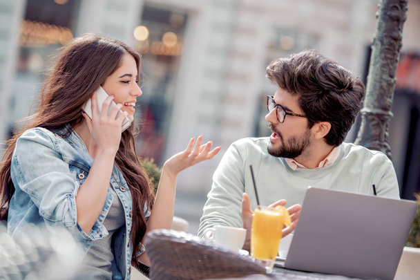 Retrato de pareja feliz en el amor tienen reunión en la cafetería y el uso de un teléfono inteligente moderno y ordenador portátil
. - Foto, imagen