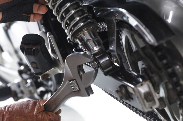 Przycięte widzenia mechanik za pomocą klucza na motocykl na białym tle - Zdjęcie, obraz