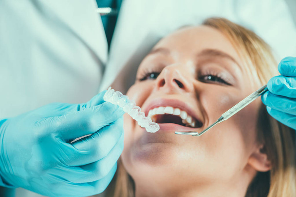  歯科歯のホワイトニングの手順を持つ若い女性 - 写真・画像