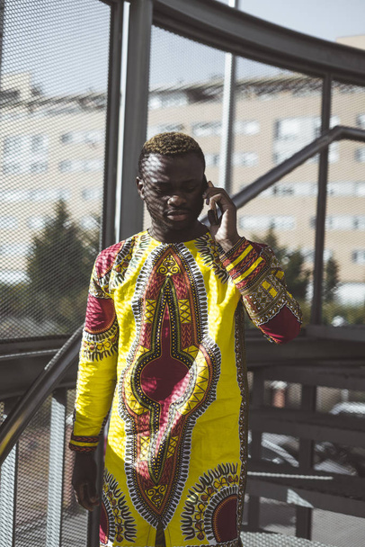 Empresario africano con smartphone y la ropa de típico
 - Foto, Imagen
