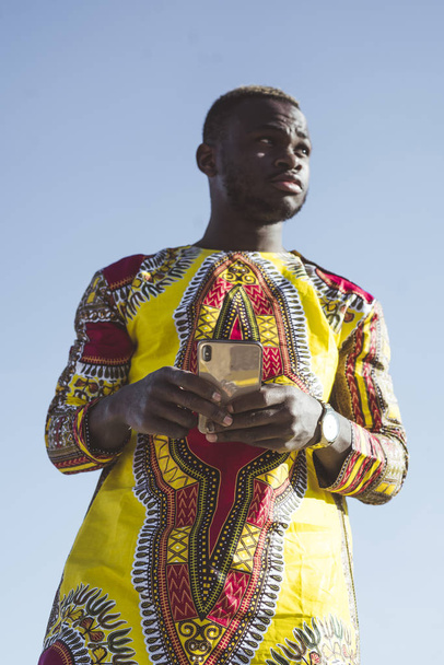 Afrikanischer Geschäftsmann mit Smartphone und typischer Kleidung - Foto, Bild