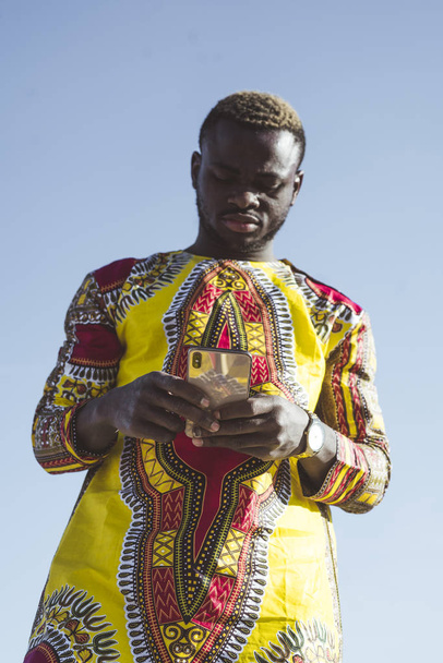 Africký podnikatel s smartphone a oblečení typické - Fotografie, Obrázek