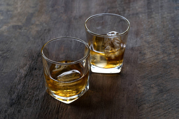Top view of Whiskey with ice in glass on wooden table  - Photo, image