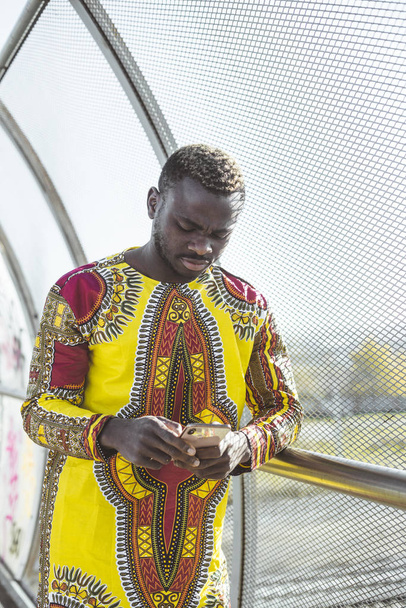 African businessman with smartphone and the clothes of typical - Photo, image